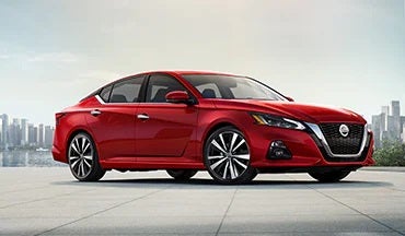 2023 Nissan Altima in red with city in background illustrating last year's 2022 model in DeLand Nissan in DeLand FL