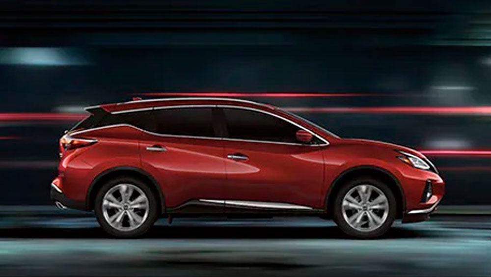 2023 Nissan Murano shown in profile driving down a street at night illustrating performance. | DeLand Nissan in DeLand FL